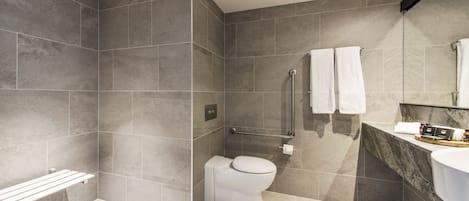 Un baño moderno con ducha, inodoro y lavamanos.