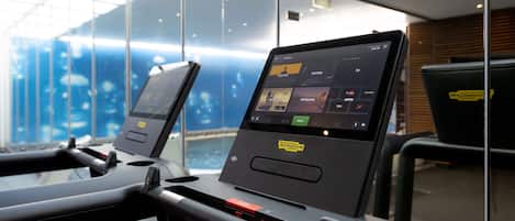 Una cinta de correr con pantalla digital y un espejo de fondo.