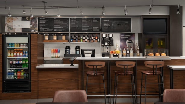A modern bistro bar with a menu board, beverage dispensers, and seating area. - Courtyard by Marriott Panama City (Panama City)
