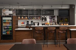 Un moderno bar bistró con una pizarra de menú, dispensadores de bebidas y una zona de estar.