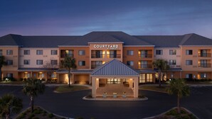 A Courtyard by Marriott hotel with a central courtyard, multiple floors, and a well-lit entrance. - Courtyard by Marriott Panama City (Panama City)