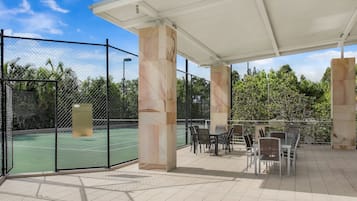 A covered outdoor area with a tennis court, seating, and a sign reading "TOWN COURT 2".