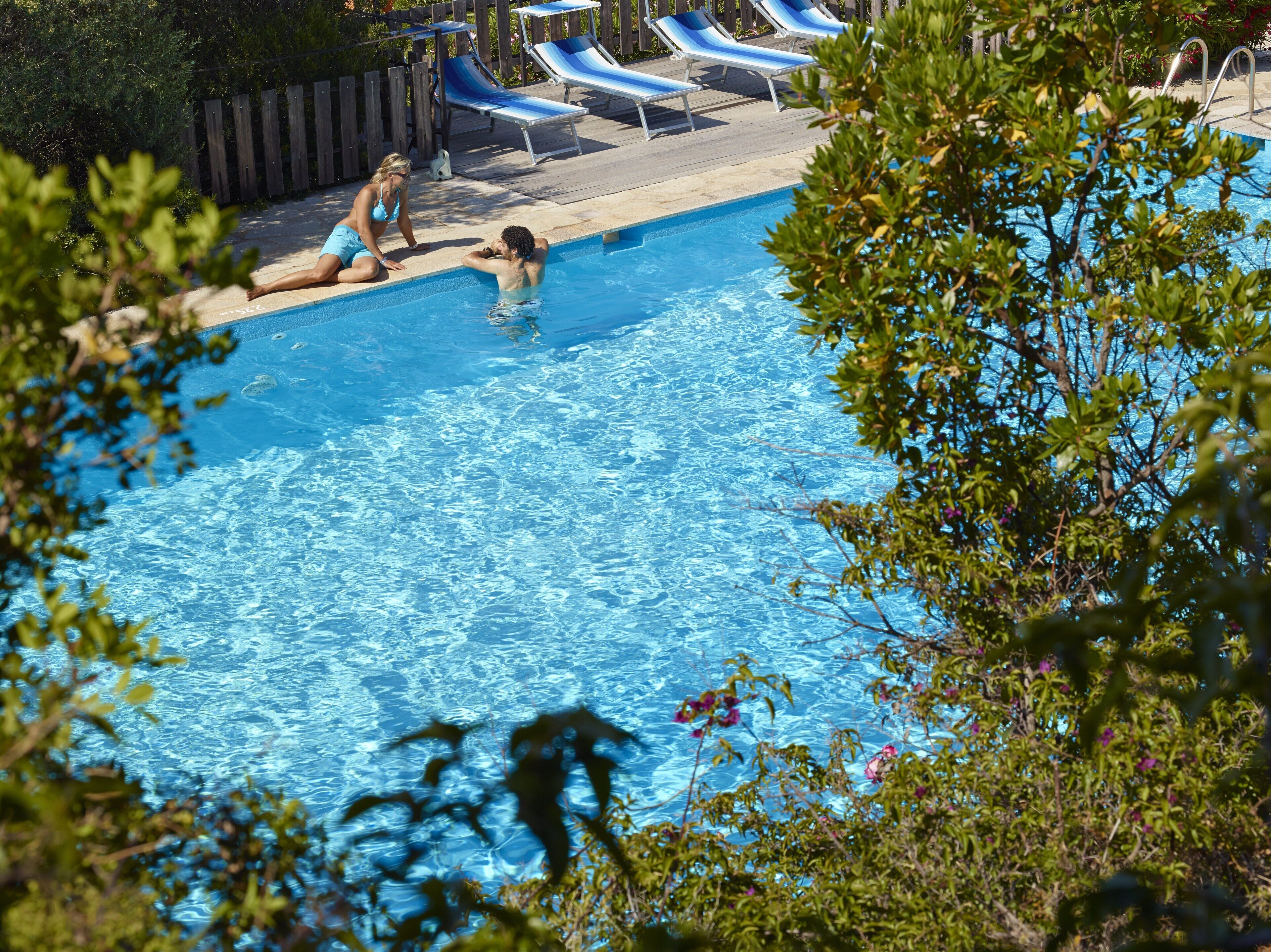 Ein Schwimmbecken mit Liegestühlen und einer Holzterrasse.