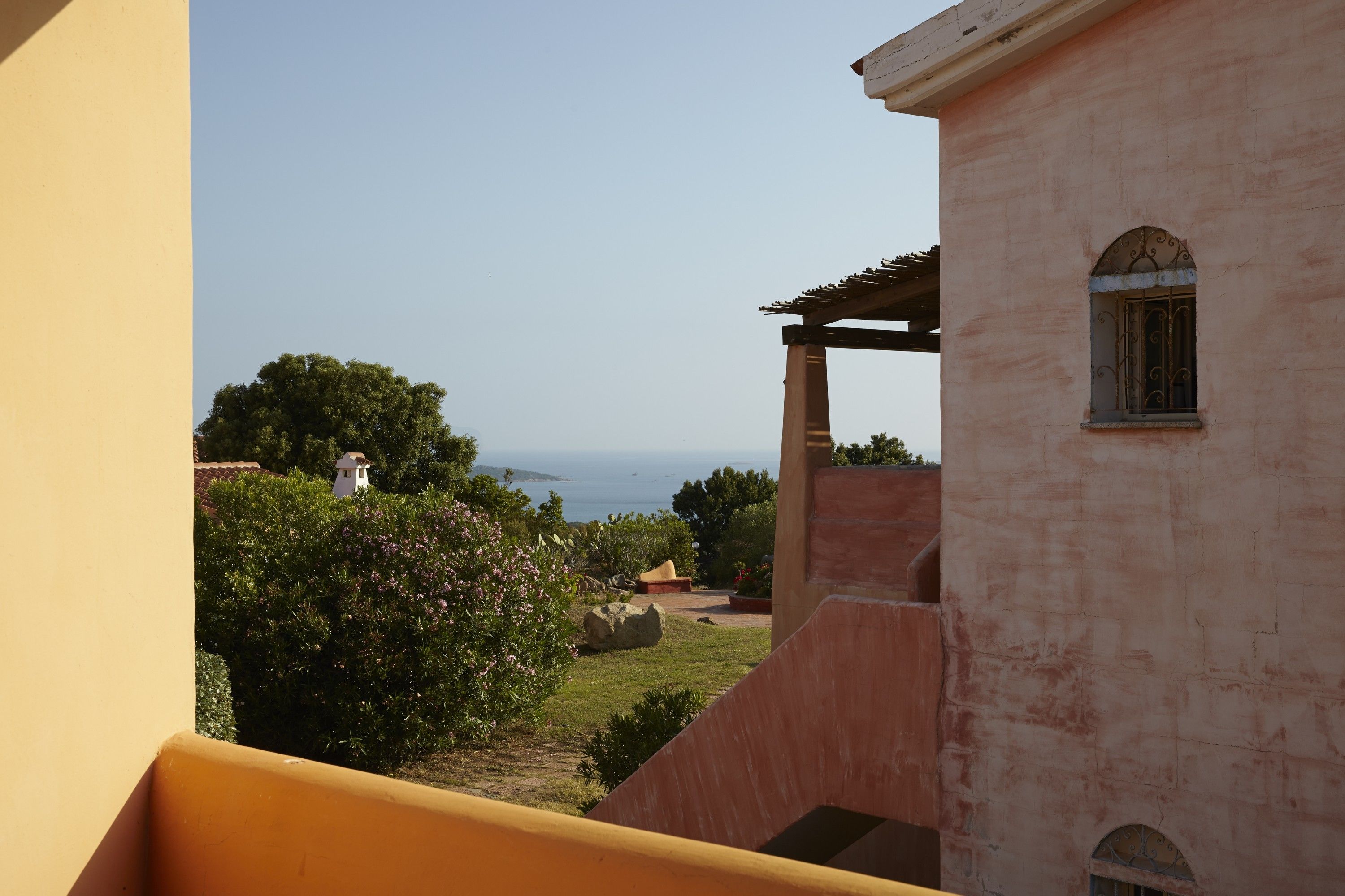 Un balcone con vista su un giardino e un edificio con una finestra.