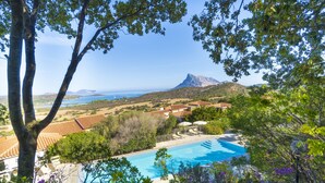 Una piscina con vista al mar y a la montaña.