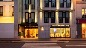 A modern hotel building with multiple floors, large windows, and illuminated exterior lighting. - Hotel Paris Bastille (Paris)