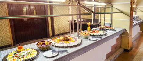A buffet setup with various dishes and a glass railing.