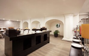 A modern breakfast bar with a variety of pastries and a coffee station.