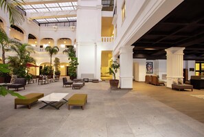 A spacious lobby with multiple seating areas, a glass ceiling, and indoor plants. - DoubleTree by Hilton Toluca (Toluca)