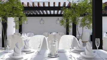 Un comedor con vajilla blanca, que incluye platos, vasos y cubiertos.