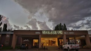 Un hotel llamado MALARCUITE con fachada moderna y entrada cubierta.