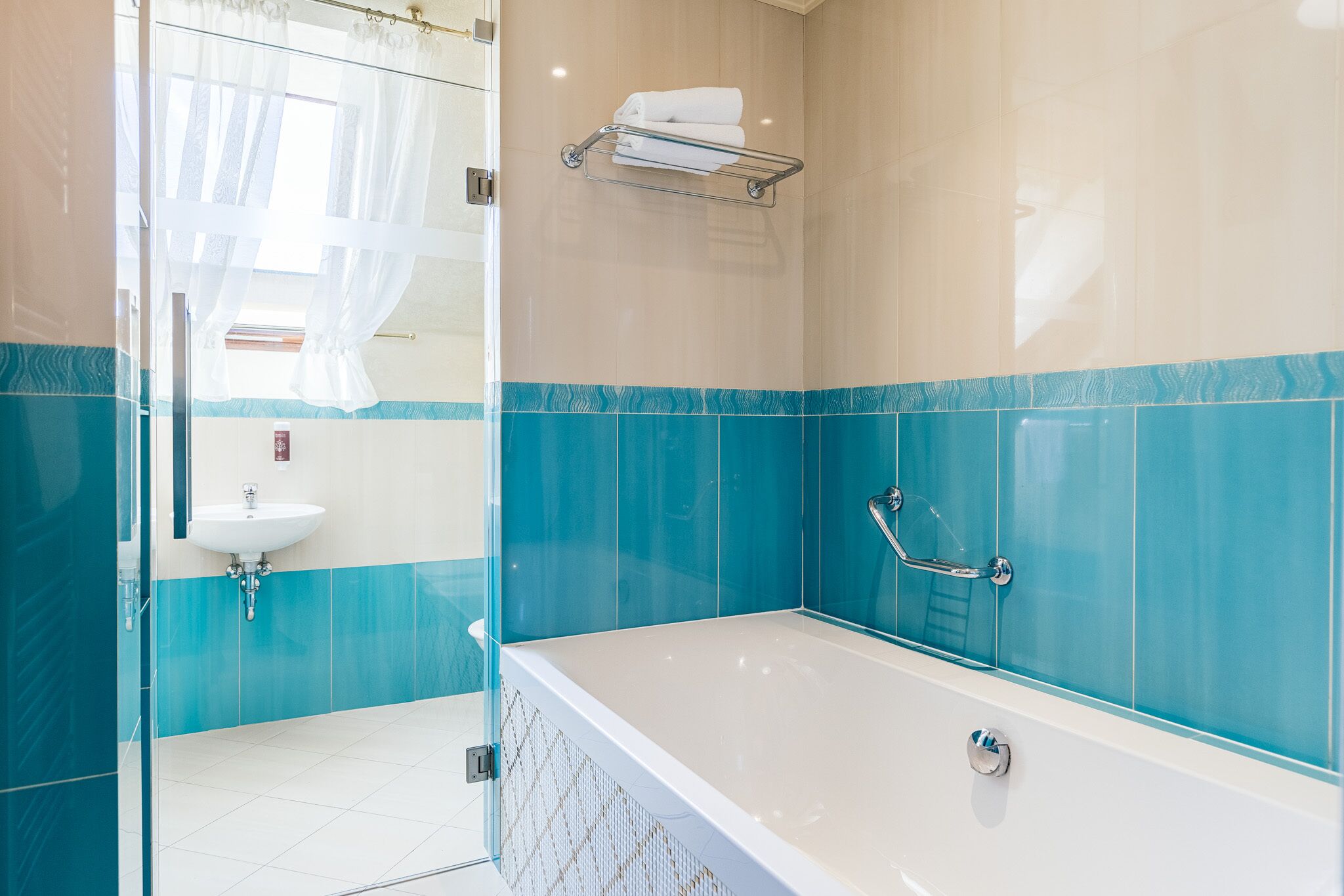 A modern bathroom with a bathtub, a glass shower enclosure, and a sink.