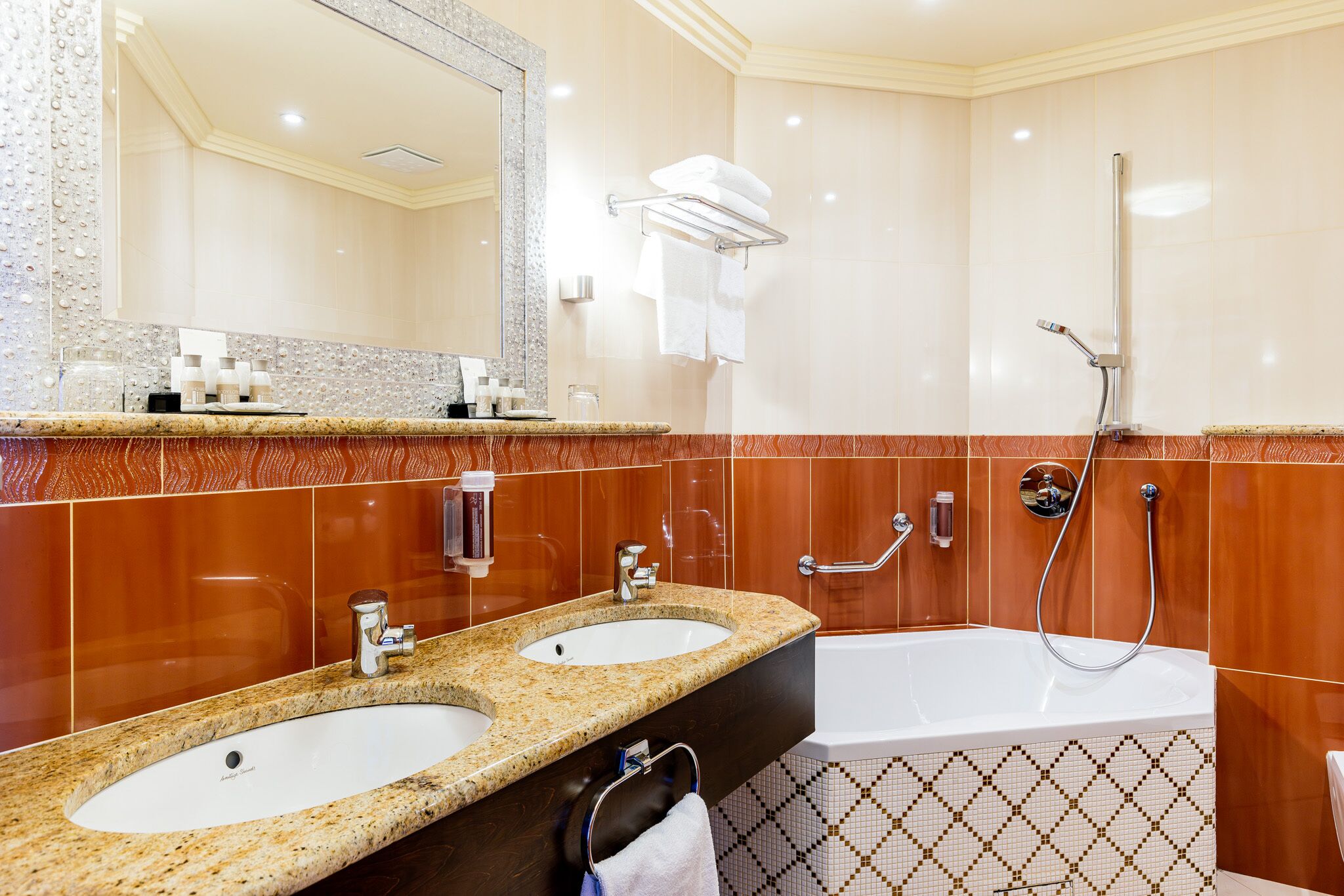 A bathroom with two sinks, a bathtub, and a shower.