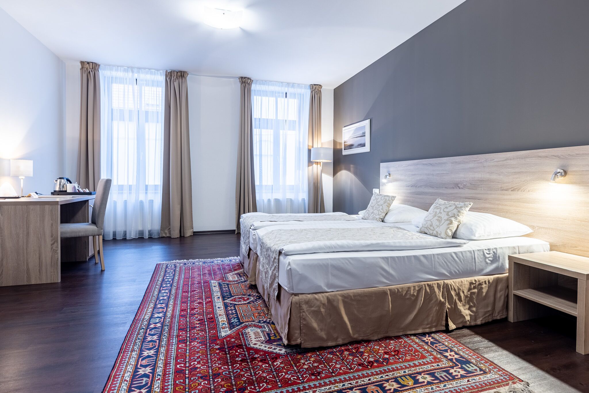 Una camera d'albergo con un letto grande, una scrivania con una sedia e un tavolino.
