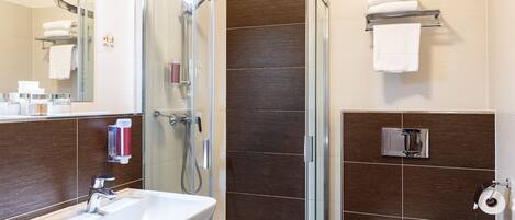 A modern bathroom with a glass-enclosed shower, a sink, a toilet, and a towel rack.