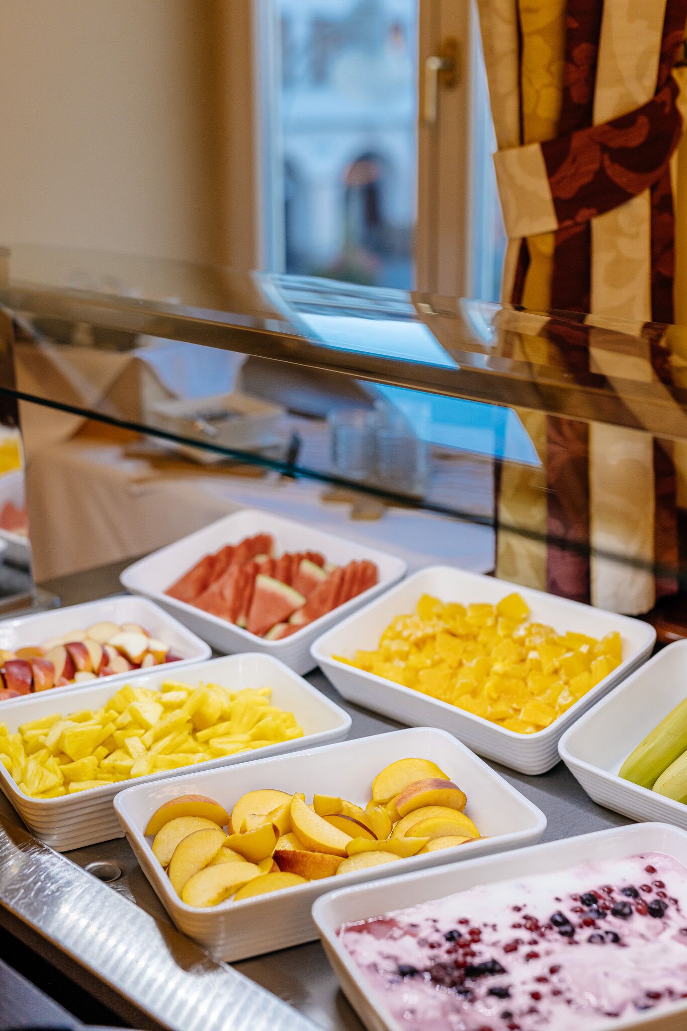 A buffet with various fruits and desserts.