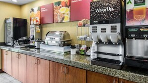 A breakfast bar with coffee machines, a food warmer, and a coffee press.