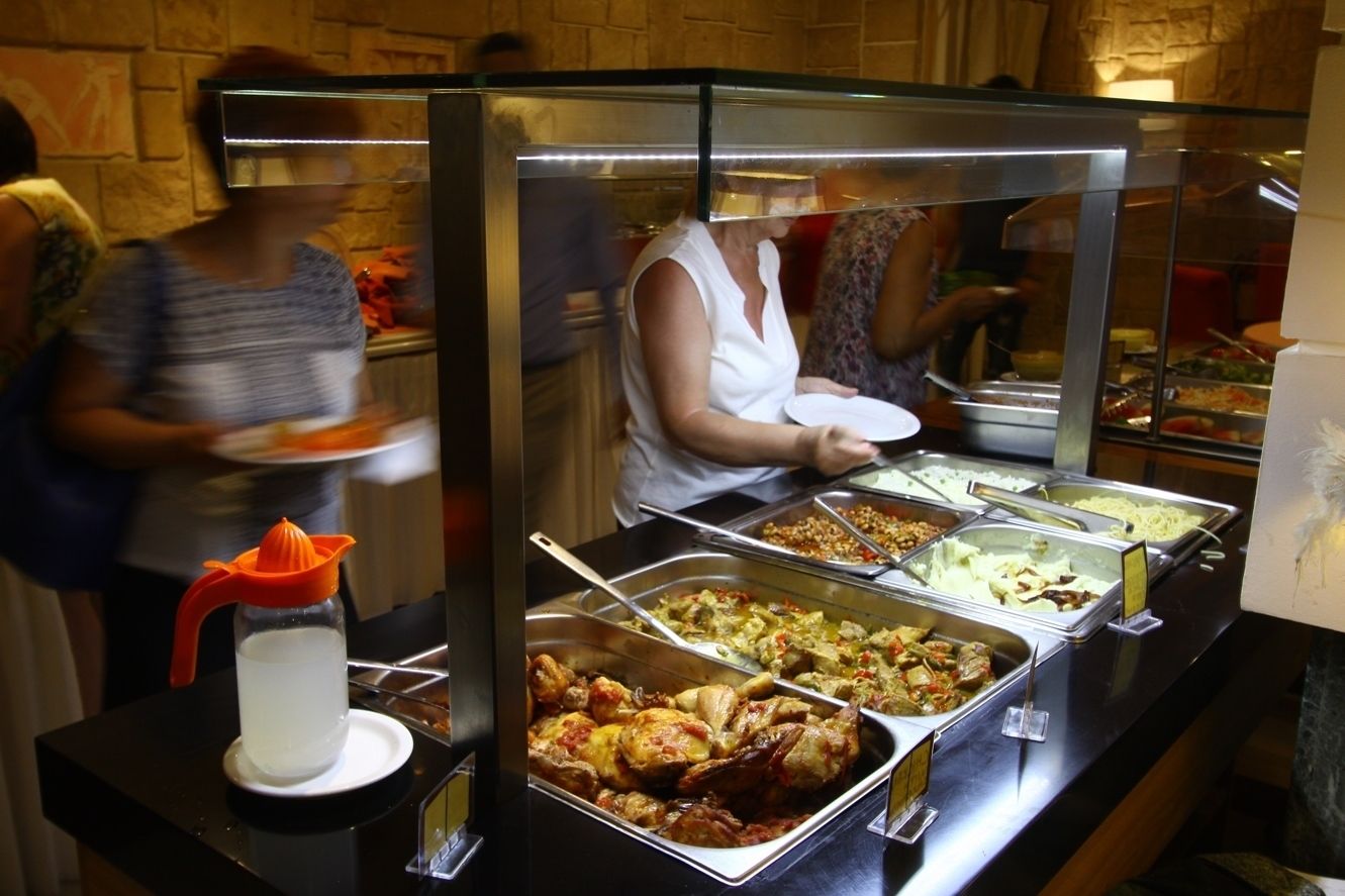 En buffet med forskellige retter og en safthane.