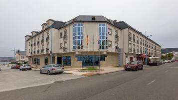 A hotel with a modern facade, multiple balconies, and a prominent entrance.