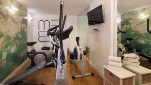 Un gimnasio en casa con bicicletas estáticas, cinta de correr y equipo de ejercicio.