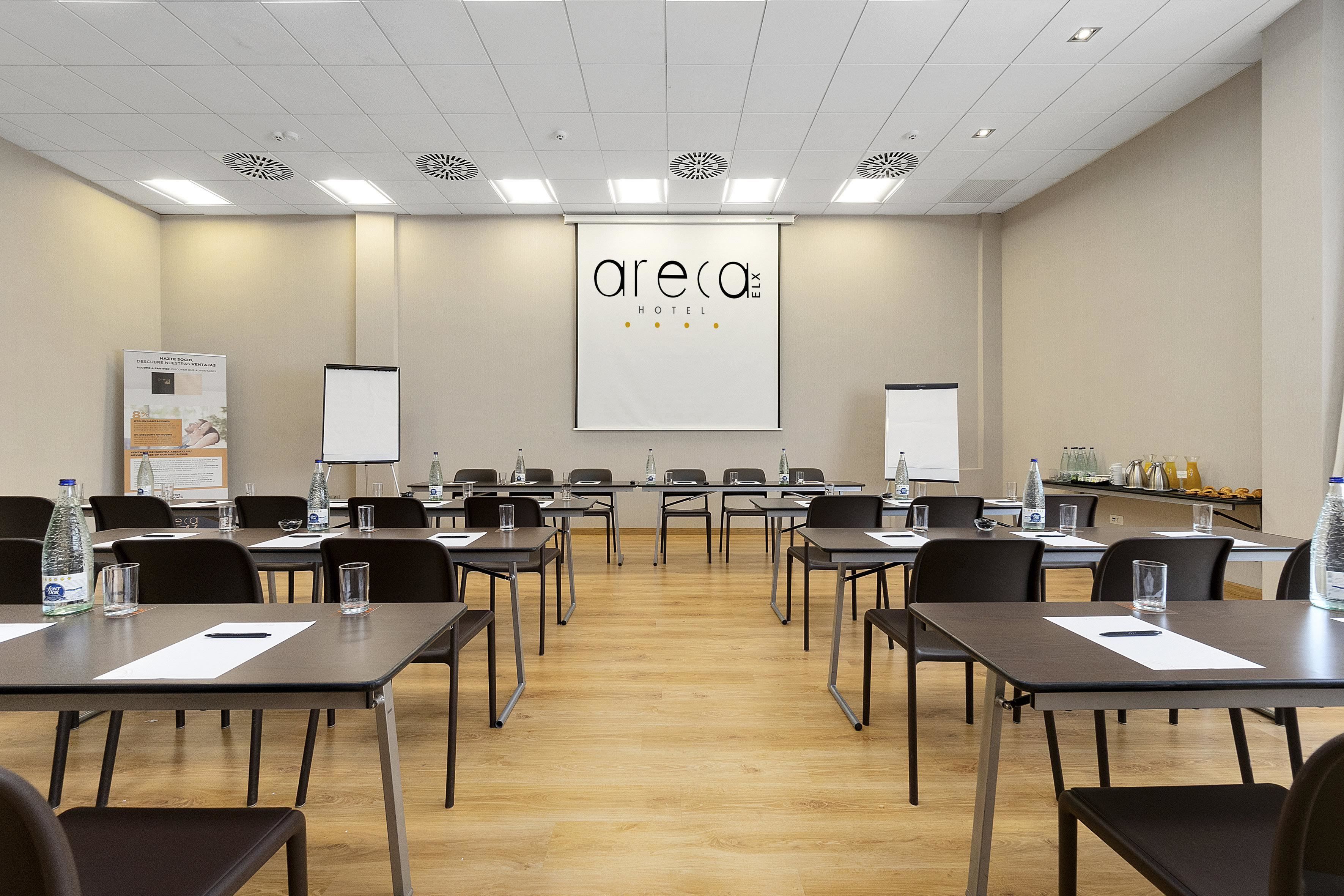 A conference room with tables, chairs, and a whiteboard.