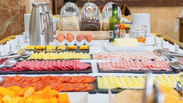 A buffet with various food items including meats, cheeses, and eggs. - Hotel Aeropuerto Sur (Granadilla de Abona)