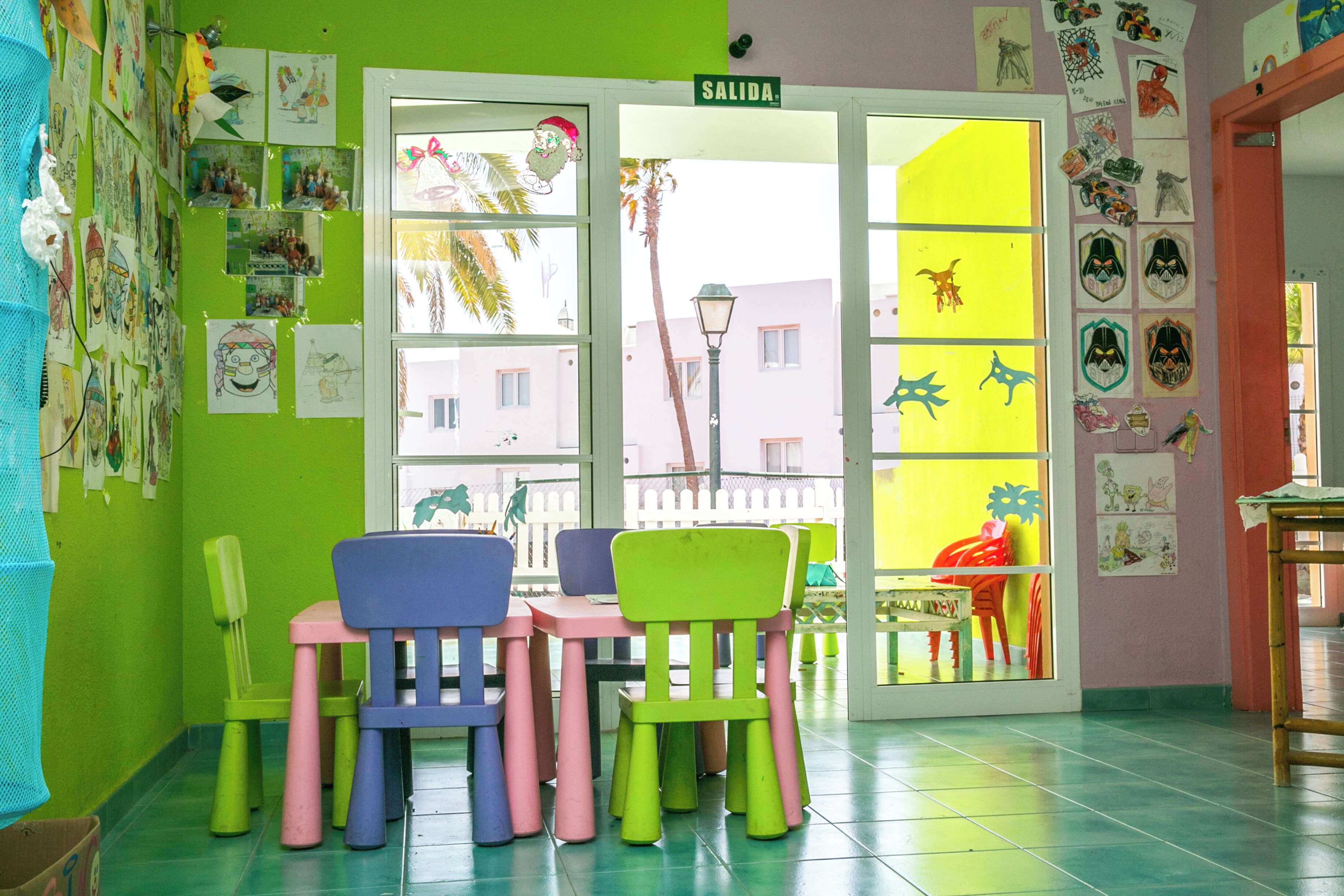 A room with colorful chairs, a table, and a door labeled "SALIDA".
