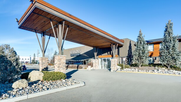 A Seasons Cafe & Eatery with a covered entrance, stone pillars, and a clear blue sky.