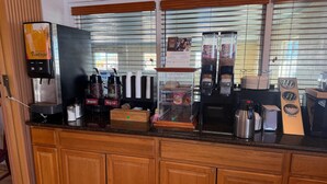 Ein Kaffee-Bereich mit einer Vintage-Kaffeemaschine, einer Kaffeemühle und einer Vitrine voller Kaffeebohnen.