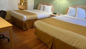 Ein Hotelzimmer mit zwei Betten, einem Schreibtisch und einem Stuhl.