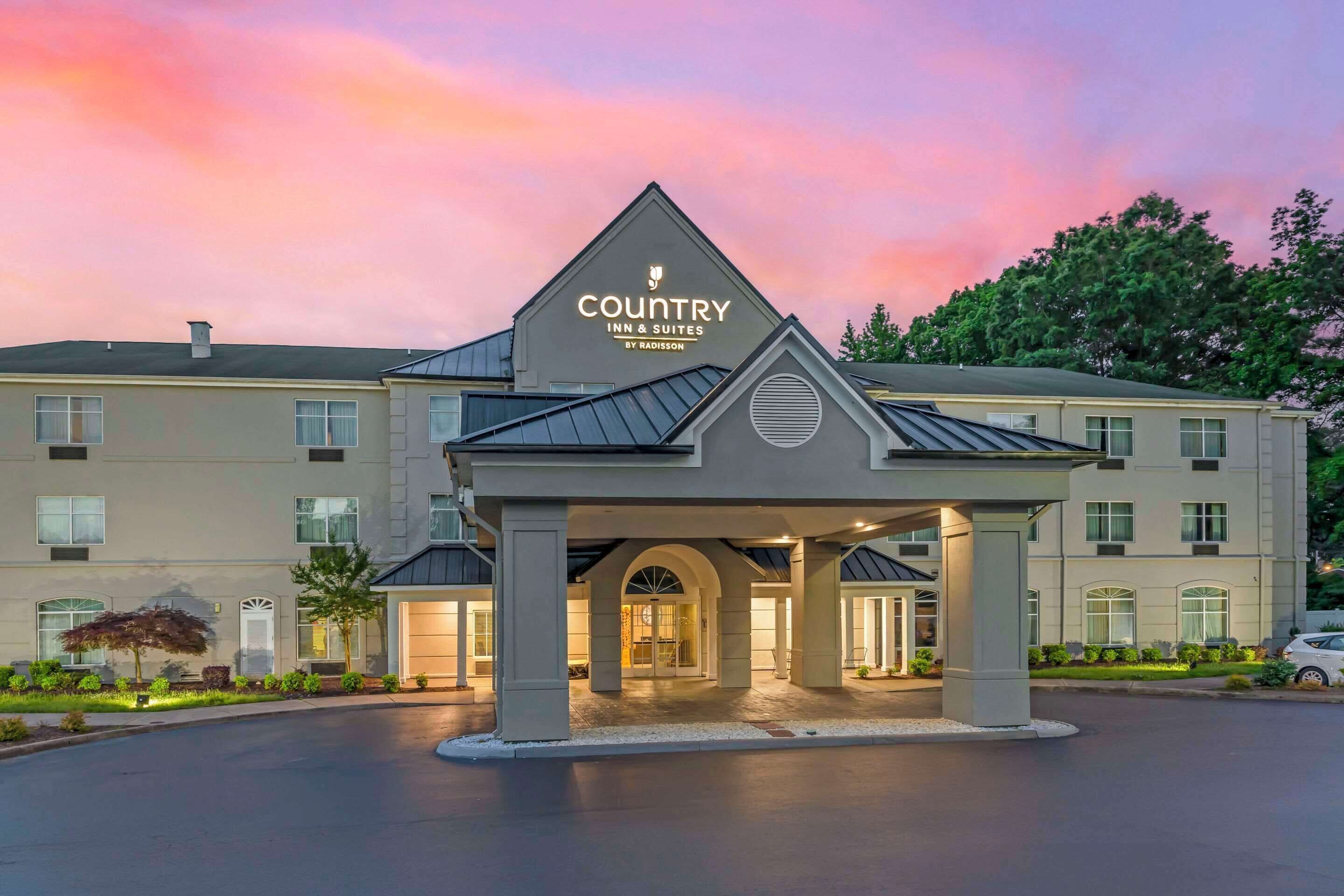 Un hôtel Country Inn & Suites by Radisson doté d’une entrée imposante et d’une allée aménagée.