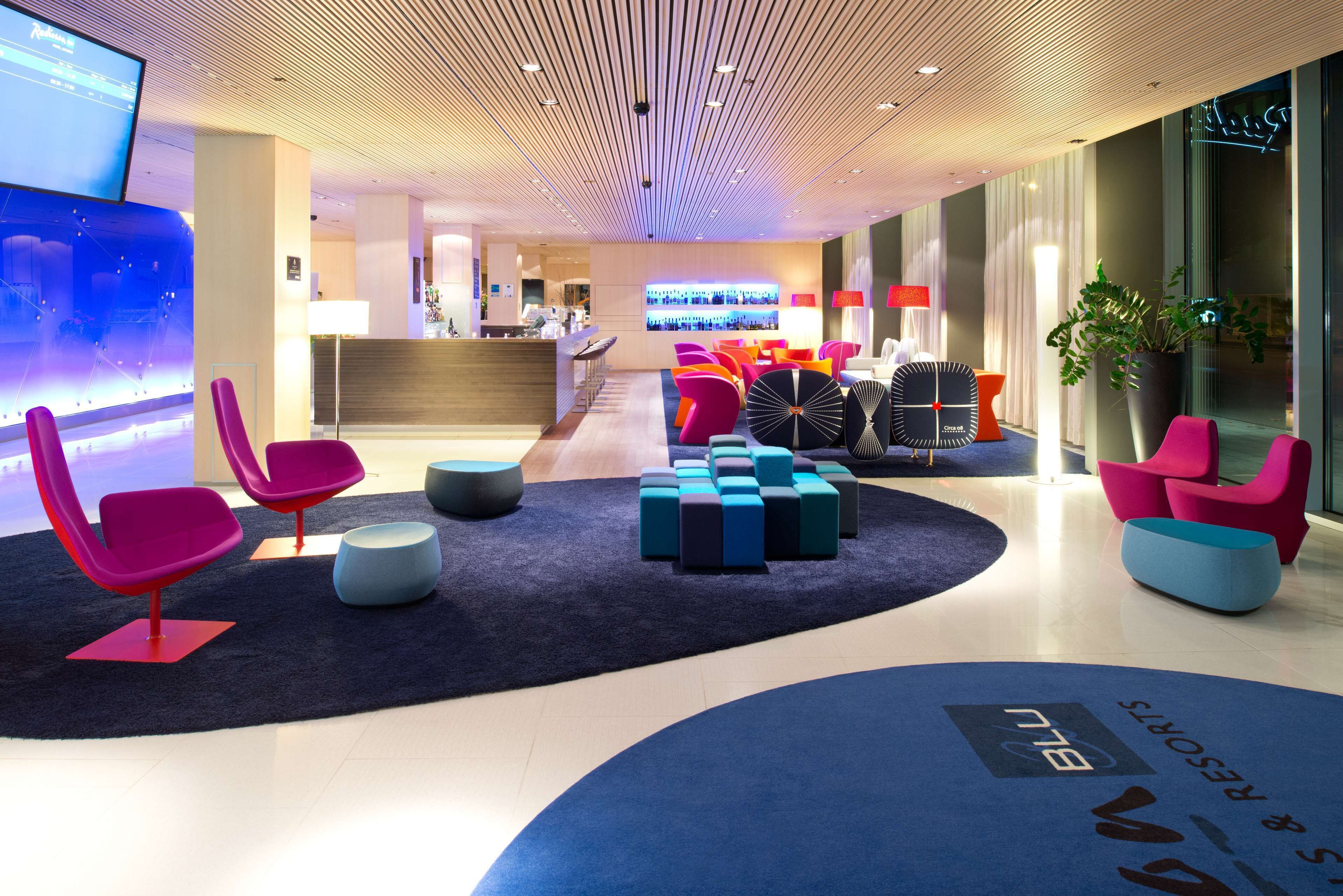 Een moderne lobby met levendige zithoeken, een receptiebalie en een bar.