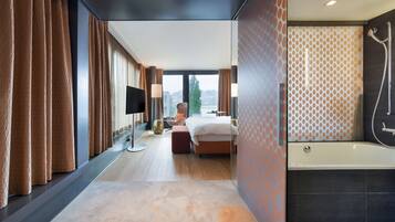 Une chambre d’hôtel moderne avec un grand lit, une télévision et une douche.