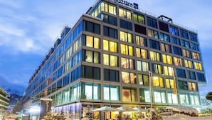 A modern hotel with multiple floors, large windows, and a prominent sign at the top. - Radisson Blu Hotel, Lucerne (Lucerne)