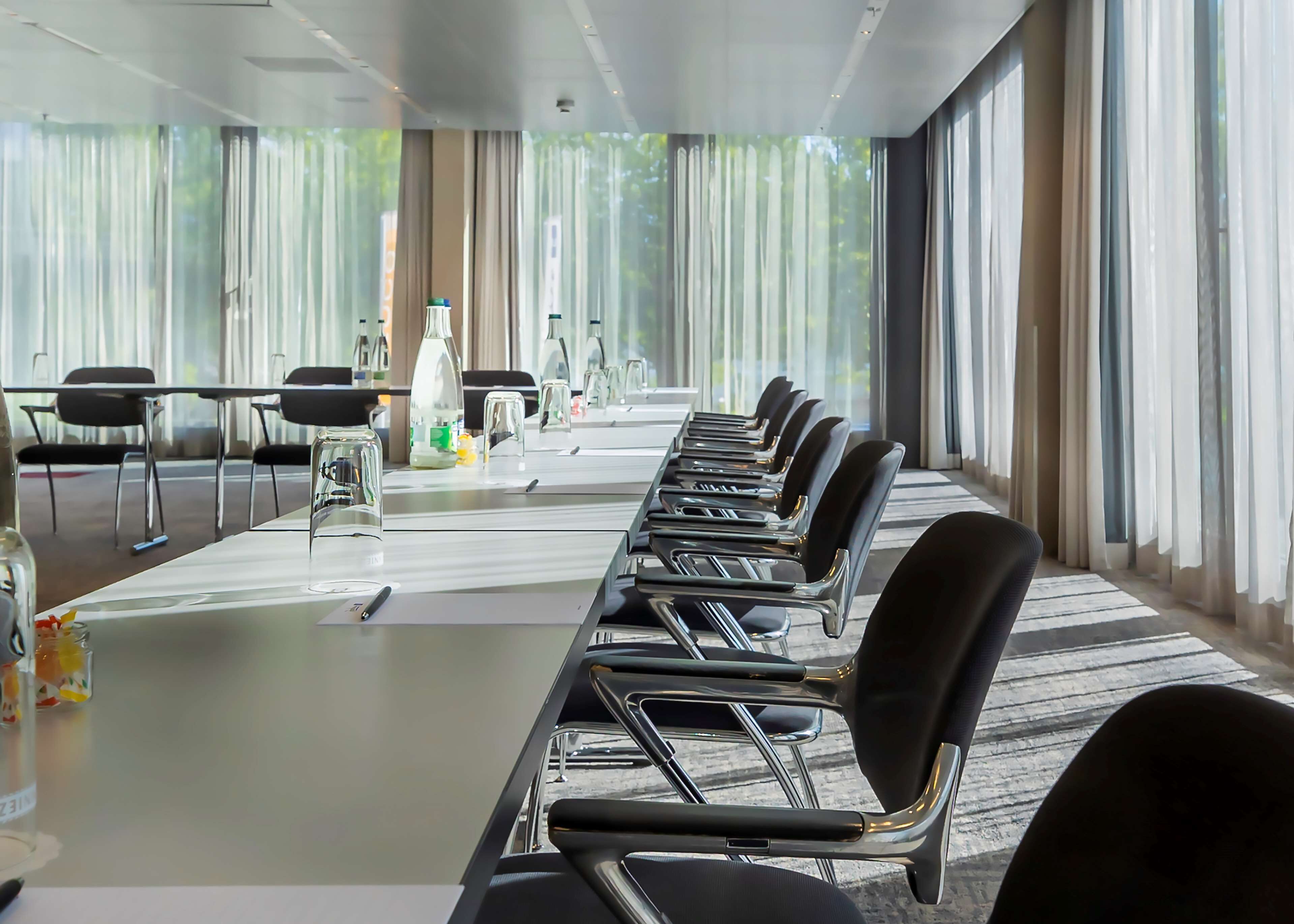 Une salle de conférence avec une longue table, des chaises et un projecteur.