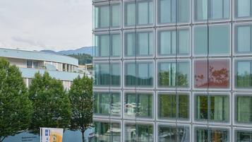 Ein Radisson BLU Hotel mit moderner Glasfassade, Außenbereich mit Sonnenschirmen und einem angelegten Garten.