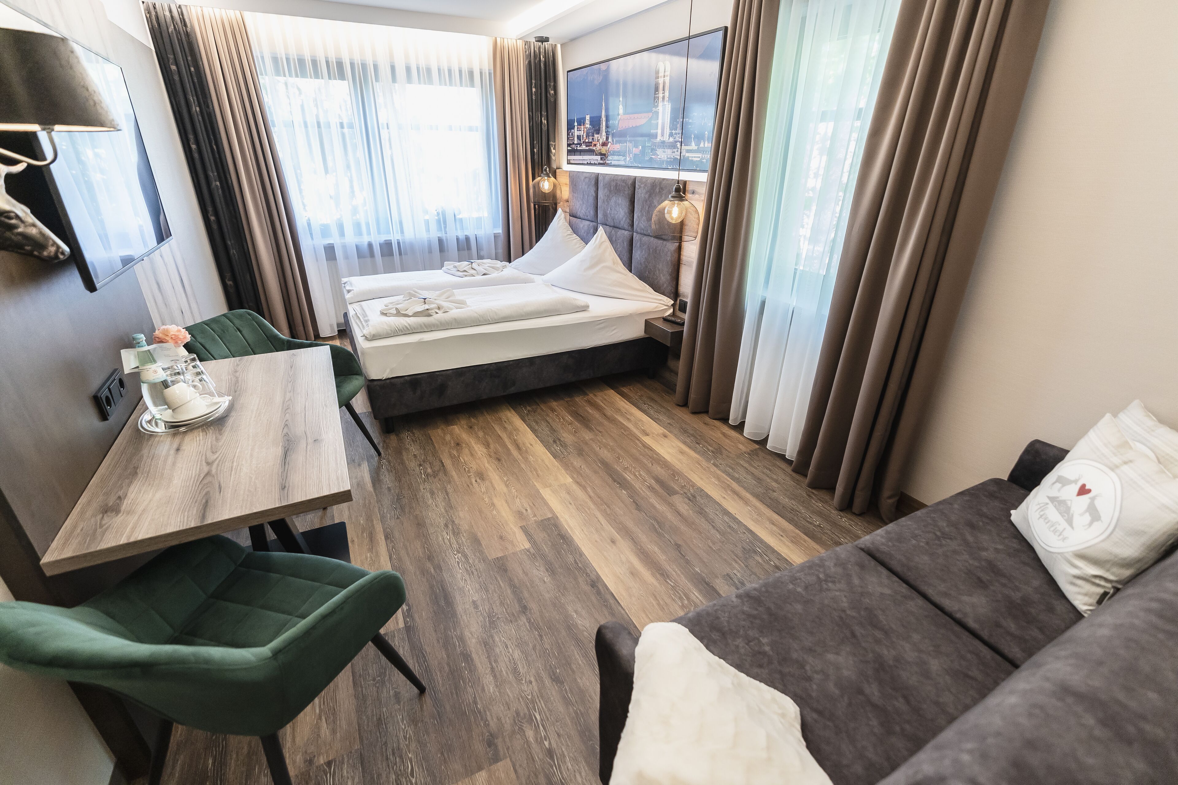Habitación de hotel con cama, escritorio, silla y sofá.