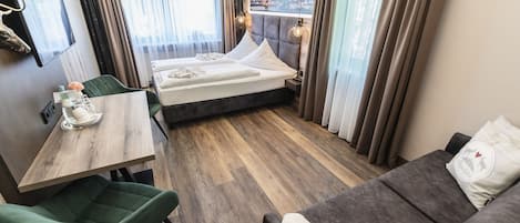 Habitación de hotel con cama, escritorio, silla y sofá.