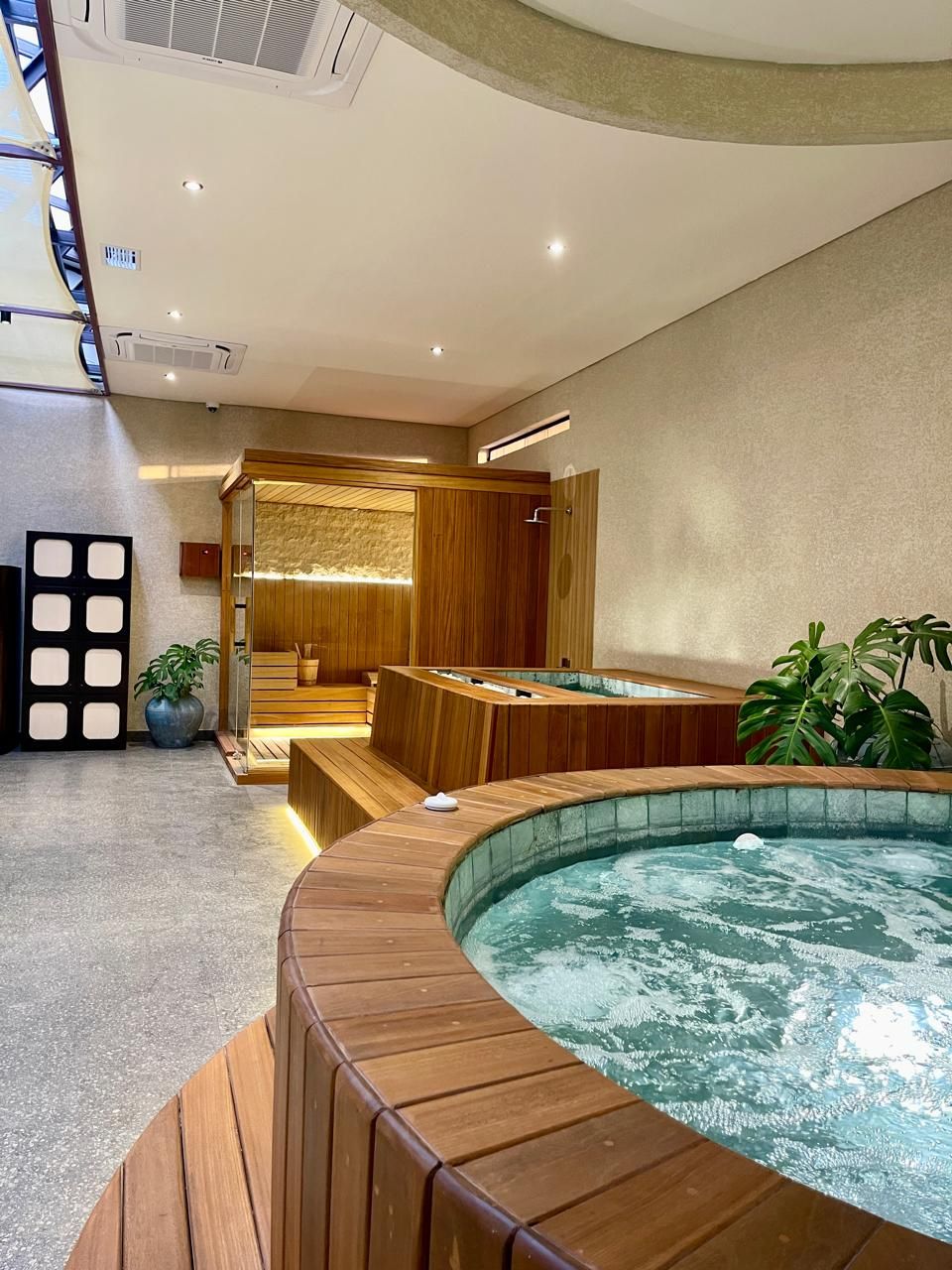 A spa area with a hot tub, wooden seating, and a sauna.