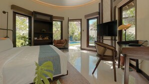 A modern bedroom with a bed, a television, a desk, and a chair. - Aruni Bali Jimbaran Boutique Villa (Jimbaran)