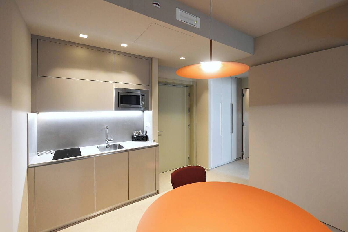 A modern kitchen with a microwave, sink, and cabinets.
