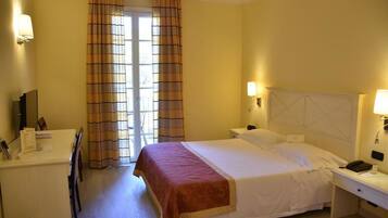 Ein Hotelzimmer mit Bett, Nachttischen, Schreibtisch und Stuhl.