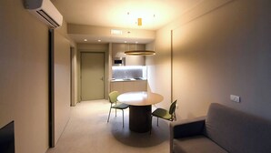 A modern, compact living space with a dining area, kitchenette, and a sofa. - Hotel Villa Cappugi (Pistoia)