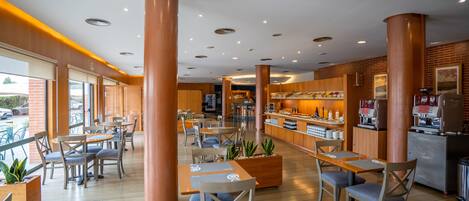 Un café moderne avec des tables et des chaises en bois, un comptoir à café et de grandes fenêtres.