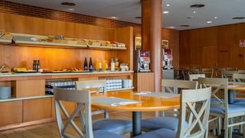 Un restaurante con paneles de madera, una máquina de café y una zona de bufé con diferentes opciones de comida.