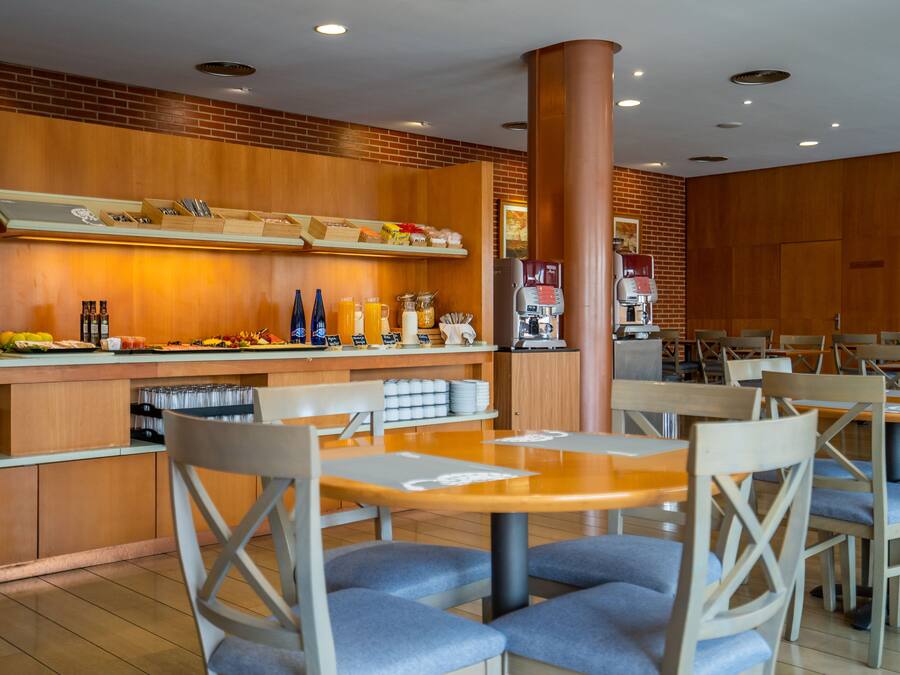 Un restaurante con paneles de madera, una máquina de café y una zona de bufé con diferentes opciones de comida.