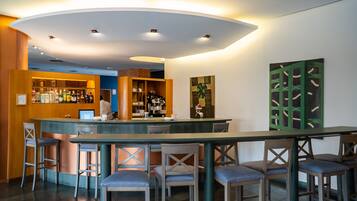 A bar area with stools, a counter, and a seating area.