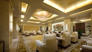 A spacious lobby with a large chandelier, multiple seating areas, and a patterned carpet. - Grand Soluxe International HOT (Xi'an)