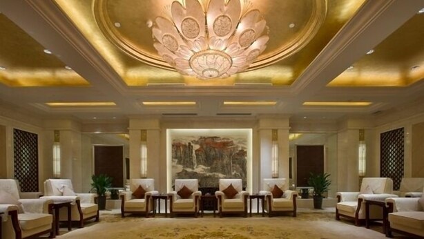 A luxurious lobby with a large, ornate ceiling, a central seating area with sofas and armchairs, and a large mural on the back wall. - Grand Soluxe International HOT (Xi'an)