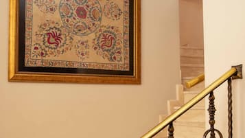Una scala con ringhiera dorata e un tappeto incorniciato con elaborate decorazioni floreali.